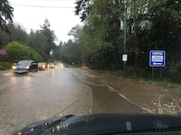 Cars move through floodwater along the Sunshine Coast Highway near Sechelt, B.C., during the atmospheric river event in a November 2021 handout photo. THE CANADIAN PRESS/HO-Ross Muirhead, *MANDATORY CREDIT*