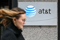 A woman walks past signage for AT&T in Washington, DC, on February 22, 2024. Nearly 75,000 AT&T customers reported cell phone service outages on February 22, 2024, according to tracking website Downdetector. The issue was clustered in several cities, including Dallas, Houston, Chicago, Atlanta and Miami, the website said. (Photo by Mandel NGAN / AFP) (Photo by MANDEL NGAN/AFP via Getty Images)