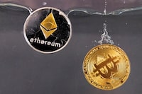 Souvenir tokens representing cryptocurrency Bitcoin and the Ethereum network, with its native token ether, plunge into water in this illustration taken May 17, 2022.