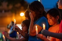People hold candles at a vigil remembering the victims of a mass stabbing incident at James Smith Cree Nation and Weldon, Sask., in front of City Hall in Prince Albert, Sask., on Wednesday, September 7, 2022. A new project in the town of Weldon is paying tribute to the memory of one of the victims of mass attack. THE CANADIAN PRESS/Heywood Yu