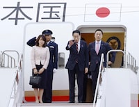 Japan's Prime Minister Fumio Kishida, center, waves, with his wife Yuko, left, as they depart for the U.S., at Haneda airport in Tokyo Monday, April, 8, 2024. Kishida is making an official visit to the United States this week. He will hold a summit with President Joe Biden that's meant to achieve a major upgrading of their defense alliance.(Kyodo News via AP)