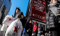 In this Nov. 29, 2019, file photo a shopper leaves Macy's department store with bags in both hands during Black Friday shopping in New York.