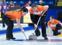 Wild Card team skip Casey Scheidegger, right, delivers a rock as third Cary-Anne McTaggart, left, and second Jessie Haughian sweep as they play Prince Edward Island at the Scotties Tournament of Hearts at Centre 200 in Sydney, N.S. on Sunday, Feb. 17, 2019. THE CANADIAN PRESS/Andrew Vaughan
