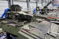 FILE PHOTO: Employees work on Puma fighting vehicles at a production line at the plant of German company Rheinmetall, which produces weapons and ammunition for tanks and artillery, during a media tour in Unterluess, Germany, June 6, 2023. REUTERS/Fabian Bimmer/File Photo