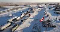 <p>A truck convoy of anti-COVID-19 vaccine mandate demonstrators block the highway at the busy U.S. border crossing in Coutts, Alta., Wednesday, Feb. 2, 2022. Opening arguments are scheduled today in the trial for three men charged for their role in the blockade of the Canada-U.S. border at Coutts, Alta. THE CANADIAN PRESS/Jeff McIntosh</p>