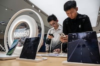 BEIJING, CHINA - SEPTEMBER 25: People look at newly launched smartphones at a Huawei flagship store after the company unveiled new products on September 25, 2023 in Beijing, China. China's Huawei recently unveiled its new line of smartphones, including the Mate 60, which features a Chinese made chip. (Photo by Kevin Frayer/Getty Images)