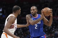 Los Angeles Clippers forward Kawhi Leonard, right, tries to pass as Phoenix Suns forward Kevin Durant defends during the second half of an NBA basketball game Monday, Jan. 8, 2024, in Los Angeles. (AP Photo/Mark J. Terrill)
