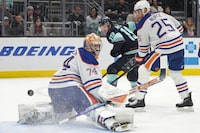 Seattle Kraken left wing Jared McCann (19) shoots the puck on net as Edmonton Oilers goaltender Stuart Skinner (74) and defenseman Darnell Nurse (25) defend during the first period of an NHL hockey game Saturday, March 2, 2024, in Seattle. (AP Photo/Jason Redmond)