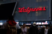 FILE PHOTO: People walk by a Walgreens, owned by the Walgreens Boots Alliance, Inc., in Manhattan, New York City, U.S., November 26, 2021. REUTERS/Andrew Kelly/File Photo