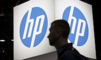 An attendee at the Microsoft Ignite technology conference walks past the Hewlett-Packard (HP) logo in Chicago, Illinois, May 4, 2015. REUTERS/Jim Young/Files