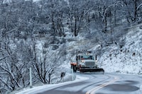 A snow plow works along Mt Hamilton road in Unincorporated Santa Clara County, Calif. Thursday, Feb. 23, 2023. (Stephen Lam/San Francisco Chronicle via AP)