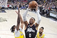 Los Angeles Clippers guard Russell Westbrook, center, shoots as Los Angeles Lakers forward Cam Reddish, left, and guard D'Angelo Russell defend during the second half of an NBA basketball game Wednesday, Feb. 28, 2024, in Los Angeles. (AP Photo/Mark J. Terrill)