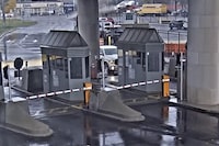 In this image taken from security video, a light colored vehicle, top center, flies over a fence into the Rainbow Bridge customs plaza, Wednesday, Nov. 22, 2023, in Niagara Falls, N.Y. The governor of New York state says there’s no apparent terrorism link to a car that hit a median at breakneck speed, soared through the air, crashed and exploded, killing two people Wednesday at a Canada-U.S. border checkpoint in Niagara Falls.THE CANADIAN PRESS/Customs Border Protection via AP