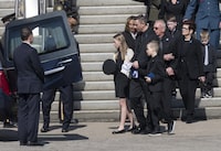 Quebec provincial police Sgt. Maureen Breau's husband, Daniel Sanscartier, and her children, Kheraly and Emrick, leave the church after her funeral service in Trois-Rivières, Que., Thursday, April 13, 2023. The family of a slain Quebec provincial police officer addressed a coroner's inquiry with her husband saying her tragic death should never have happened. THE CANADIAN PRESS/Ryan Remiorz