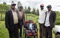 Kibore Cheruiyot Ngasura, 105, a member of the Talai community, which accuses the British colonial government of displacing them from their farms, pose for a picture with his sons outside his house ahead of Britain's King Charles' and Queen Camilla's visit to Kenya, in Tugunon village of Kericho County, Kenya October 25, 2023. REUTERS/Monicah Mwangi
