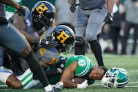 Saskatchewan Roughriders running back Jamal Morrow (25) is tackled by Hamilton Tiger-Cats defenders during the first half of CFL football action at Mosaic Stadium in Regina, on Saturday, Oct. 7, 2023. THE CANADIAN PRESS/Heywood Yu