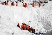 In this photo released by Xinhua News Agency, Rescuers search for survivors following an avalanche in Nyingchi, southwest China's Tibet Autonomous Region on Friday, Jan. 20, 2023. More bodies were found Friday following an avalanche that buried vehicles outside a highway tunnel in Tibet, raising the death toll more than a dozen with several people still missing. (Sun Fei/Xinhua via AP)