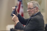 Lucien Haag, a witness on forensic science firearms evidence examination and shooting reconstruction, shows the jury a gun like the one used in rehearsal for the film "Rust" during the Hanna Gutierrez-Reed trial at District Court in Santa Fe, N.M., on Tuesday, Feb. 27, 2024. (Luis Sánchez Saturno/Santa Fe New Mexican via AP, Pool)