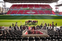 Politicians and stakeholders gather around a microphone during an announcement at Toronto's BMO Field on Friday, May 3, 2024, which revealed $104 million in federal funding for Toronto to host six games during the 2026 FIFA World Cup. THE CANADIAN PRESS/Chris Young 