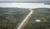 Vehicles line-up for fuel at Fort Providence, N.W.T., on the only road south from Yellowknife, Thursday, Aug. 17, 2023. THE CANADIAN PRESS/Jeff McIntosh