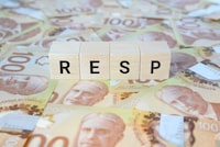 RESP (Registered Education Savings Plan) on wooden blocks and Canadian 100 dollar bills.