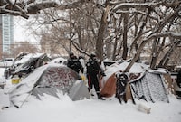 An editor with an online media outlet says Edmonton police have arrested one of his reporters as they broke up a homeless encampment in the city. Police inspect a homeless encampment as residents and supporters have a stand off as police prepare to clear homeless encampments in Edmonton, Tuesday, Jan. 9, 2024. THE CANADIAN PRESS/Jason Franson.