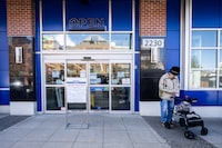 A woman waits outside of the London Drugs Broadway and Vine location in Vancouver. on Monday, April 29, 2024. London Drugs says it has temporarily closed all of its stores in Western Canada as it grapples with a "cybersecurity incident."  THE CANADIAN PRESS/Ethan Cairns 