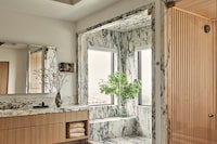 Interior designers are incorporating steam showers, natural ambient lighting and organic materials to help home bathrooms mimic a spa experience.