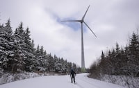 Samuel Drouin-Tardif, an electro-mechanic for Boralex, walks in the snow while looking at a wind turbine in Thetford Mines November 24, 2023.