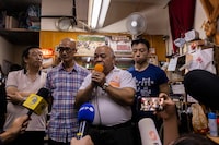 "The Bull" Tsang Kin-shing, center, founder of Hong Kong's pro-democracy Citizens' Radio station, along with radio's guests, speaks to the press prior to the radio's last broadcast in Hong Kong, Friday, June 30, 2023. (AP Photo/Louise Delmotte)