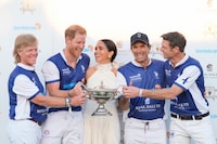 Britain's Prince Harry, center left, and wife Meghan Markle, Duchess of Sussex, center, laugh together as she presents him and his polo teammates with the trophy for winning the 2024 Royal Salute Polo Challenge to Benefit Sentebale, Friday, April 12, 2024, in Wellington, Fla. Teammates pictured, from left, are Dana Barnes, Adolfo Cambiaso, and Malcolm Borwick. (AP Photo/Rebecca Blackwell)