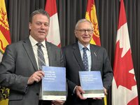 New Brunswick Natural Resources Minister Mike Holland and Premier Blaine Higgs hold up booklets on the province's energy plan, in Fredericton on Wednesday, Dec.13, 2023. The New Brunswick Progressive Conservative government has put out a 12-year energy road map that proposes moving toward a carbon neutral plan through solar, wind and nuclear sources, which was panned by the Opposition as being light on details. THE CANADIAN PRESS/Hina Alam