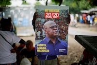 A supporter of holds a portrait of president Felix Tshisekedi of Union for Democracy and Social Progress (UDPS) as they prepares to celebrate ahead of the announcement of provisional results of the December presidential election, at their party's headquater in Kinshasa, Democratic Republic of Congo December 31, 2023. REUTERS/Justin Makangara