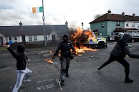 Members of nationalist group 'Dissident Republicans' throw petrol bombs at a police car as nationalists hold an anti-agreement rally on the 25th anniversary of the peace deal, in Londonderry, Northern Ireland, April 10, 2023. REUTERS/Clodagh Kilcoyne