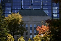 The Bank of Canada's governing council agreed the odds of another rate hike have decreased during its discussions ahead of the interest rate decision earlier this month. The Bank of Canada is framed by fall coloured leafs in Ottawa on Monday, Oct. 23, 2023. THE CANADIAN PRESS/Sean Kilpatrick