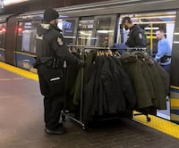 A still from a handout video posted on social media shows Metro Vancouver Transit Police on Monday, Dec. 25, 2023, removing a rolling rack of coats from a SkyTrain car. Police say a 35-year-old man has been arrested and released pending charges after being found with the rack of allegedly stolen coats. THE CANADIAN PRESS/HO-TikTok, Jahir Tapia *MANDATORY CREDIT*