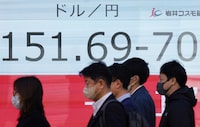 People walk past an electronic board showing the rate of the Japanese yen versus the US dollar along a street in Tokyo on March 27, 2024. (Photo by Kazuhiro NOGI / AFP) (Photo by KAZUHIRO NOGI/AFP via Getty Images)