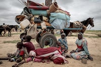 FILE PHOTO: A Sudanese family who fled the conflict in Murnei in Sudan's Darfur region, sit beside their belongings while waiting to be registered by UNHCR upon crossing the border between Sudan and Chad in Adre, Chad, July 26, 2023. REUTERS/Zohra Bensemra/File Photo
