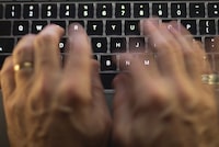 A new watchdog report says Canada's electronic spy agency needs to clearly spell out how its cyberoperations comply with international law. A man uses a computer keyboard in Toronto in a Sunday, Oct. 9, 2023 photo illustration. THE CANADIAN PRESS/Graeme Roy
