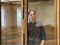 FILE PHOTO: Wall Street Journal reporter Evan Gershkovich, who is in custody on espionage charges, stands behind a glass wall of an enclosure for defendants as he attends a court hearing to consider extending his detention in Moscow, Russia, March 26, 2024. Moscow City Court's Press Office/Handout via REUTERS/ File photo