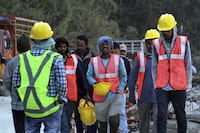 Rescuers walk near the site of an under-construction road tunnel that collapsed in mountainous Uttarakhand state, India, Friday, Nov. 17, 2023. Rescuers drilled deeper into the rubble of a collapsed road tunnel in northern India on Friday to fix wide pipes for 40 workers trapped underground for a sixth day to crawl to their freedom. (AP Photo)
