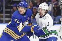 Buffalo Sabres right wing Tage Thompson (72) and Vancouver Canucks defenseman Quinn Hughes (43) battle for position in front of the net during the first period of an NHL hockey game Saturday, Jan. 13, 2024, in Buffalo, N.Y. (AP Photo/Jeffrey T. Barnes)