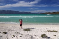 A caucasian man taking an image on beautiful Coronado Beach near Loreto, Mexico.