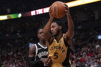 Toronto Raptors' Immanuel Quickley shields the ball from Brooklyn Nets' Dennis Schroder  during NBA basketball action in Toronto on Thursday, February 22, 2024. THE CANADIAN PRESS/Chris Young