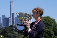 Jannik Sinner of Italy kisses the Norman Brookes Challenge Cup at a photo shoot the morning after defeating Daniil Medvedev of Russia in the men's singles final at the Australian Open tennis championships in Melbourne, Australia, Monday, Jan. 29, 2024. (AP Photo/Andy Wong)