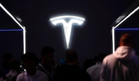 Visitors walk in front of the logo of Tesla during the International Motor Show IAA in Munich, Germany on Sept. 6.