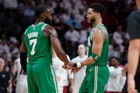 Boston Celtics forward Jayson Tatum (0) and guard Jaylen Brown (7) congratulate each other during the second half of Game 4 during the NBA basketball playoffs Eastern Conference finals against the Miami Heat, Tuesday, May 23, 2023, in Miami. (AP Photo/Wilfredo Lee)