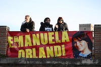 People hold a banner during a sit in, in the memory of Emanuela Orlandi, a teenager who disappeared in 1983 in one of Italy's darkest mysteries, behind St Peter's Square in the Vatican in Rome on January 14, 2023. - The Vatican announced on January 10, 2022 the opening of an investigation into the 1983 disappearance of a teenage girl living in the Vatican, a case that has never been solved and was the subject of a documentary on Netflix. (Photo by Vincenzo PINTO / AFP) (Photo by VINCENZO PINTO/AFP via Getty Images)