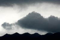 FILE PHOTO: Dark clouds gather over the mountains in Zhaoqing, southern China's Guangdong province, June 27, 2005. REUTERS/Jason Lee/File Photo