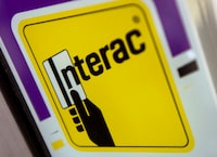 A Interac sign is seen on a business storefront in North Vancouver, B.C., on November, 5, 2019. Interac says more than a billion debit mobile contactless and in-app transactions happened over the past 12 months for the first time ever. Canada's national debit network says Interact payments through mobile contactless jumped 53 per cent while e-commerce purchases were up 17 per cent. THE CANADIAN PRESS/Jonathan Hayward